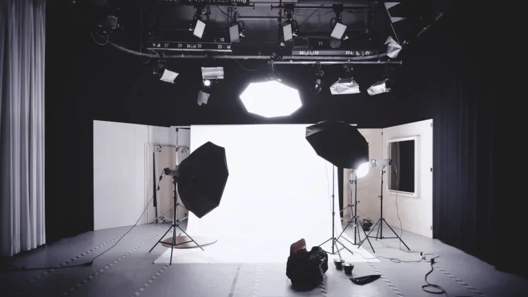 Photographer using artificial lighting equipment to create controlled illumination, dramatic shadows, and a visually appealing aesthetic effect in photography.