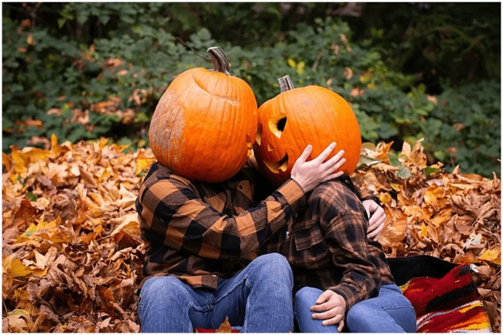 Happy couple wearing pumpkin heads during a creative Halloween photoshoot with a romantic theme