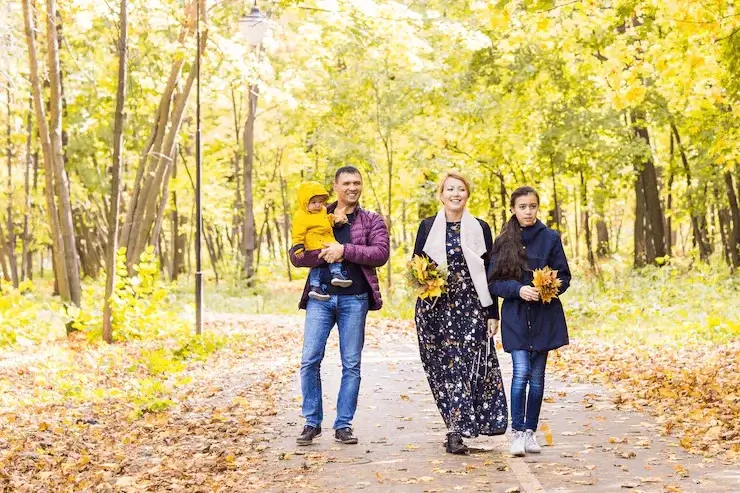 Family wearing colorful fall outfits in rich autumn shades, creating a vibrant and coordinated look for an outdoor seasonal photoshoot.