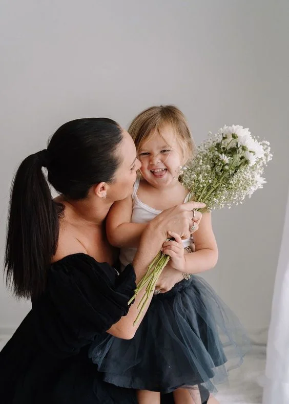 Mother Daughter Posing with a White Flower 
